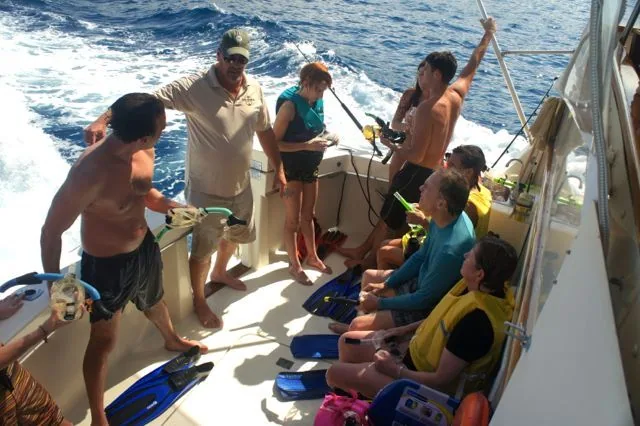 A group of people are on a boat in the ocean