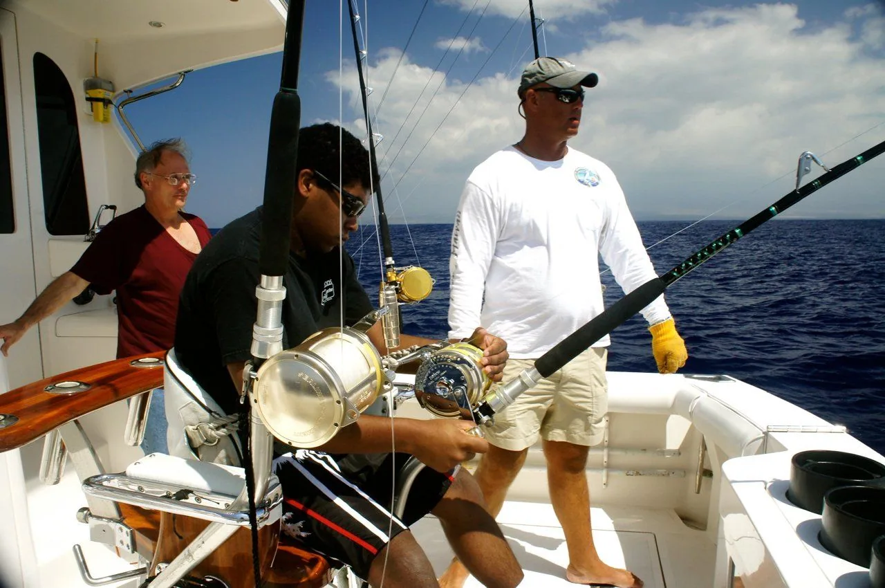 Two men are fishing on a boat in the ocean