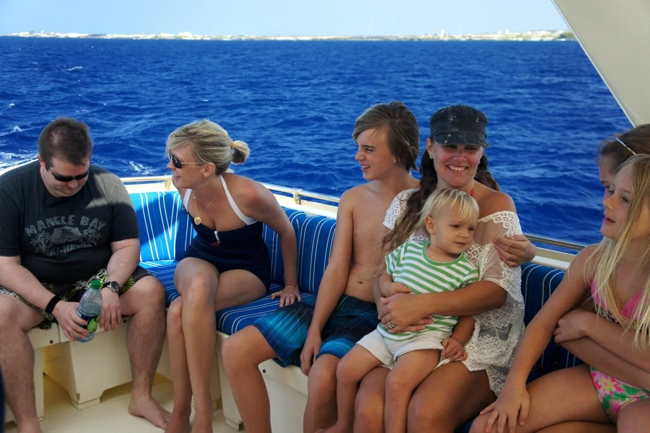 A group of people are sitting on a boat in the ocean