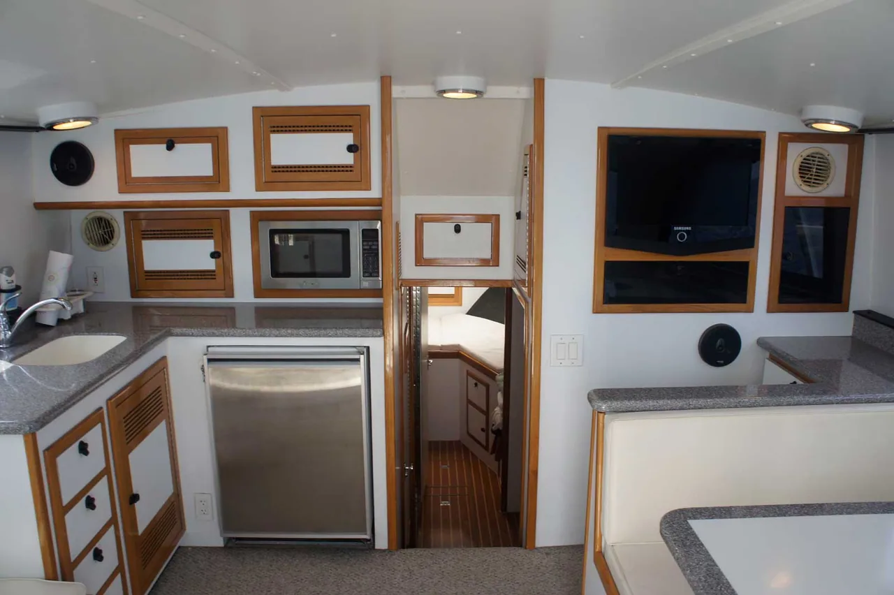 Marlin Grando: galley on a boat with stainless steel appliances and a television